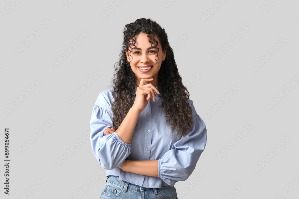 Happy young African-American woman in stylish blue collar shirt on grey background Happy young African-American woman in stylish blue collar shirt on grey background