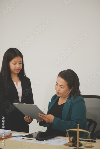 Pretty Asian female lawyer working and hammer, laptop, justice advice and legal concept. In office