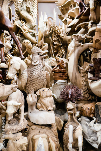 Various handmade wooden statues and carvings at Sukawati Art Market, showcasing intricate craftsmanship and traditional Balinese designs. Culture, art, travel, and souvenirs for tourist photo