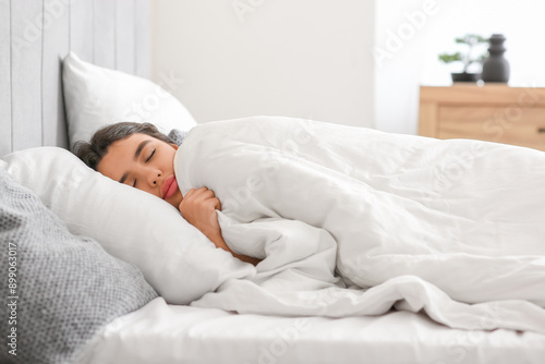 Beautiful young woman sleeping in bedroom at home