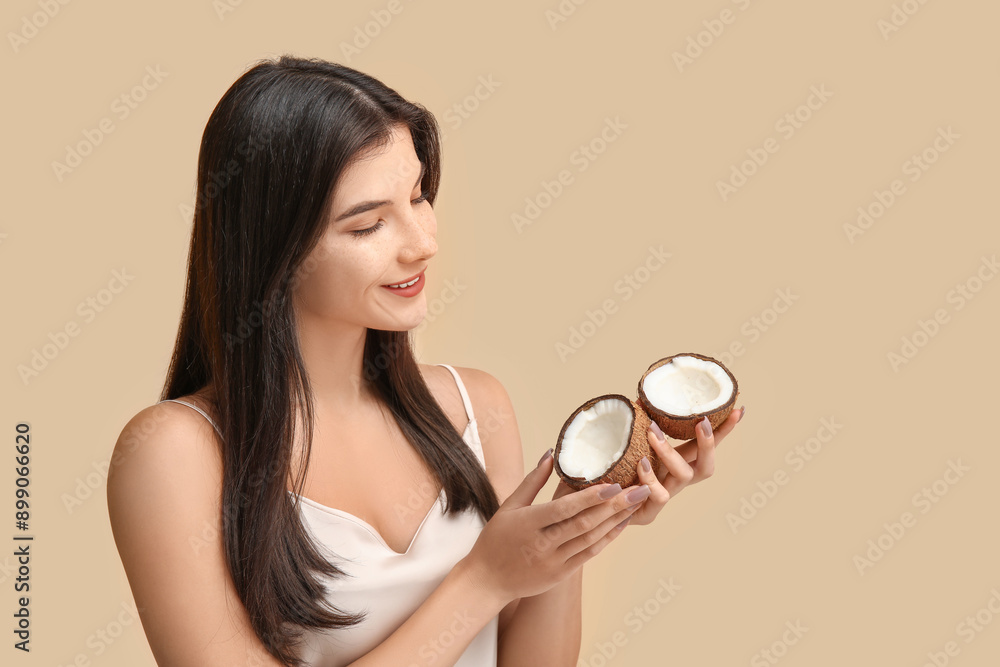 Beautiful young woman with coconut on beige background. Hair treatment Beautiful young woman with coconut on beige background. Hair treatment