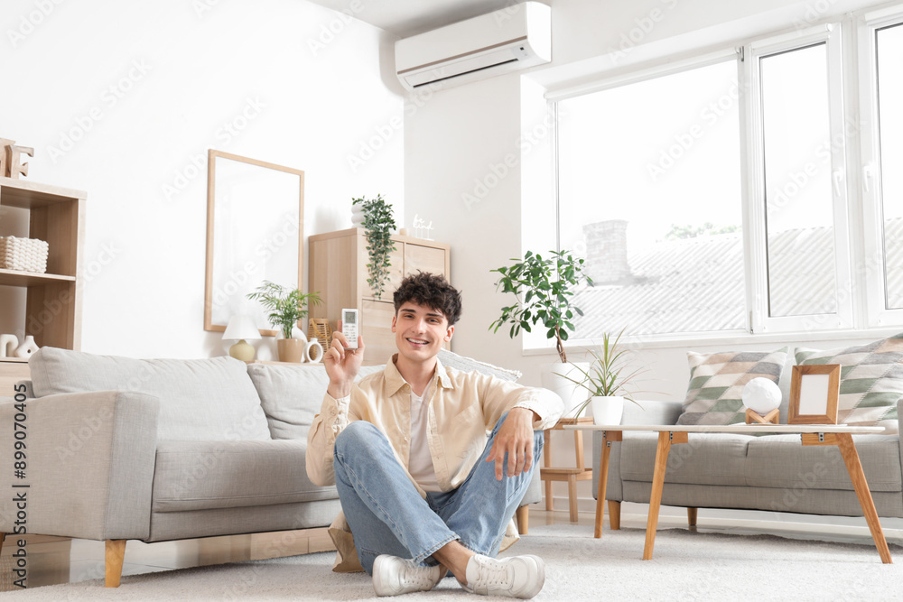 Young man switching on air conditioner at home Young man switching on air conditioner at home