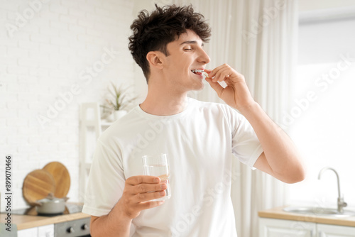 Young man taking fish oil i...