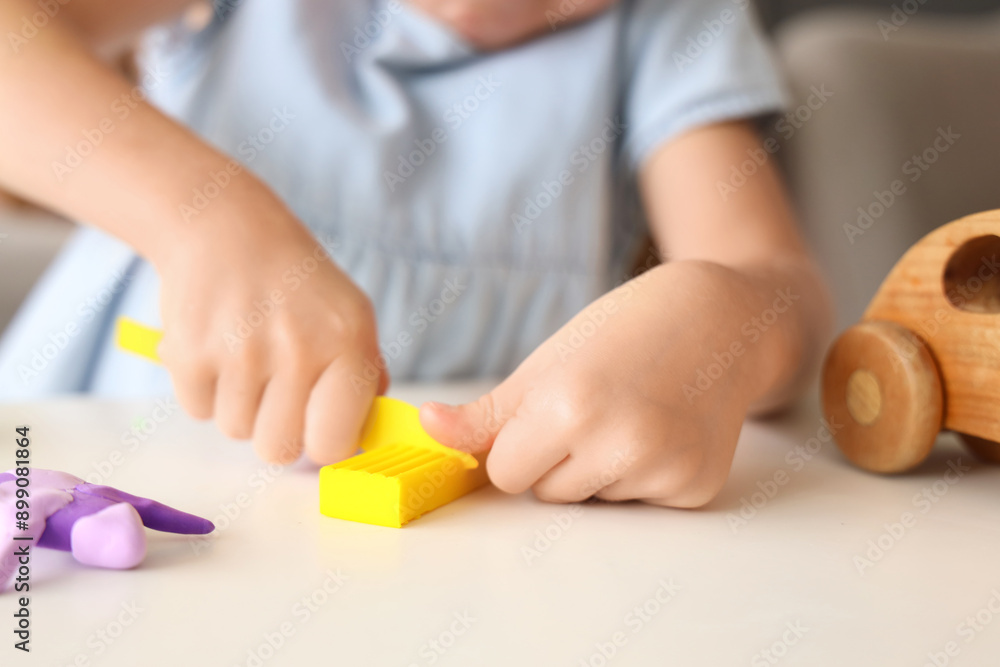 Cute little girl sculpting from plasticine at table, closeup Cute little girl sculpting from plasticine at table, closeup
