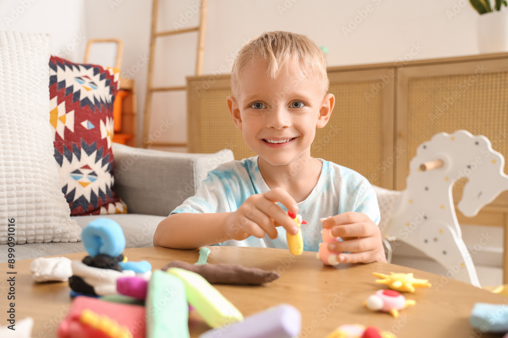 Cute little boy playing with figures made of plasticine at home Cute little boy playing with figures made of plasticine at home