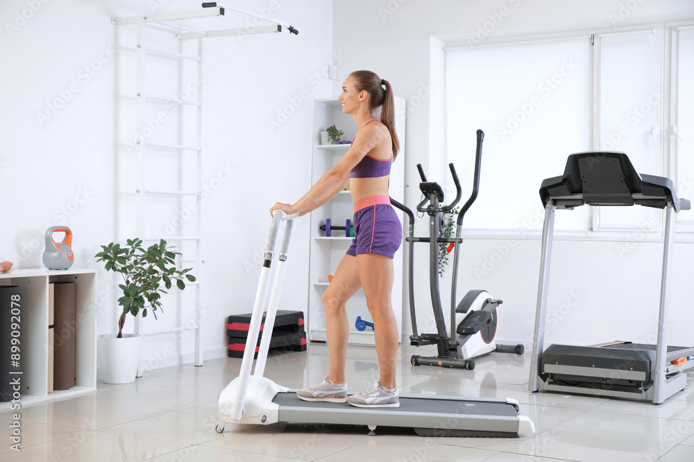 Sporty young woman training on treadmill in gym Sporty young woman training on treadmill in gym