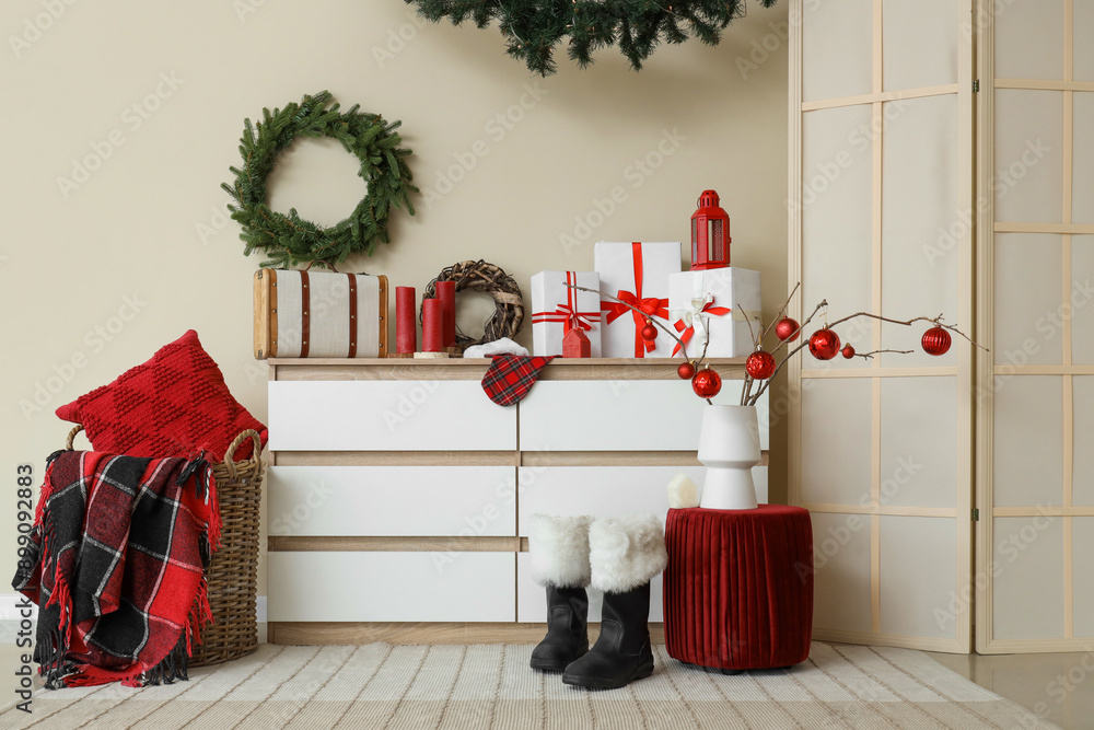 Obraz premium Interior of room with Christmas wreaths, drawers and pouf