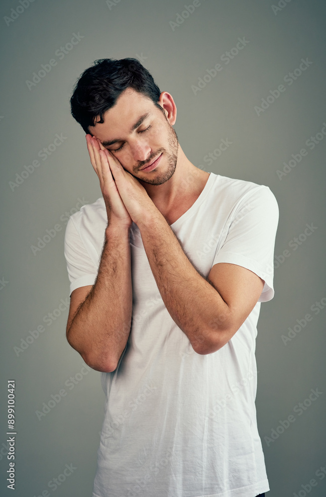 Studio, sleeping and man with gesture, tshirt and relax for dreaming in break of weekend, calm and rest. Grey background, peace and nap for wellness, person and model with comfort of hands in USA Studio, sleeping and man with gesture, tshirt and relax for dreaming in break of weekend, calm and rest. Grey background, peace and nap for wellness, person and model with comfort of hands in USA
