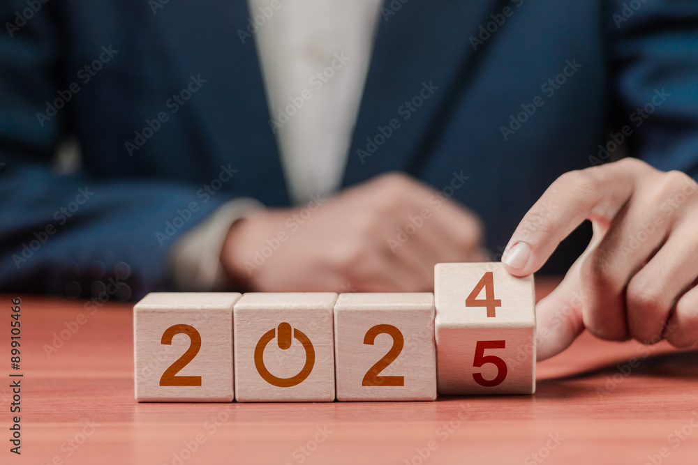 2025 growth business. Businessman hold wooden block with 2024 change to 2025, setup objective target business cost and budget planning for new year concept.. 2025 growth business. Businessman hold wooden block with 2024 change to 2025, setup objective target business cost and budget planning for new year concept..