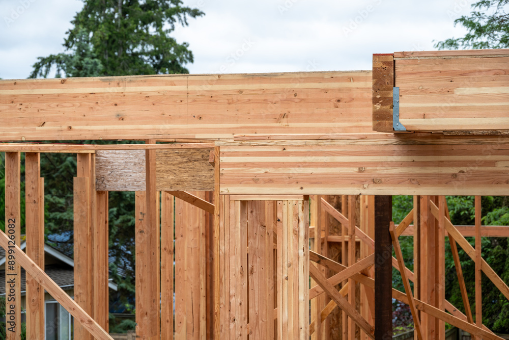 Closeup detail of new house construction, large glue laminate wood support beams and Parallel Strand Lumber support beams, building framing started with walls and windows
Closeup detail of new house construction, large glue laminate wood support beams and Parallel Strand Lumber support beams, building framing started with walls and windows
