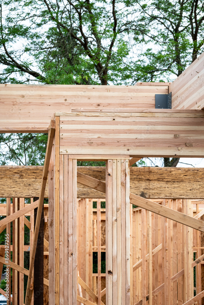 Closeup detail of new house construction, wall wood framing started and glue laminate header beam installed, structural support
Closeup detail of new house construction, wall wood framing started and glue laminate header beam installed, structural support