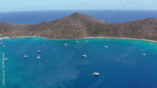 Panning and Tilting Down Over Blue Water BVI Cove with Sailboats - Norman Island