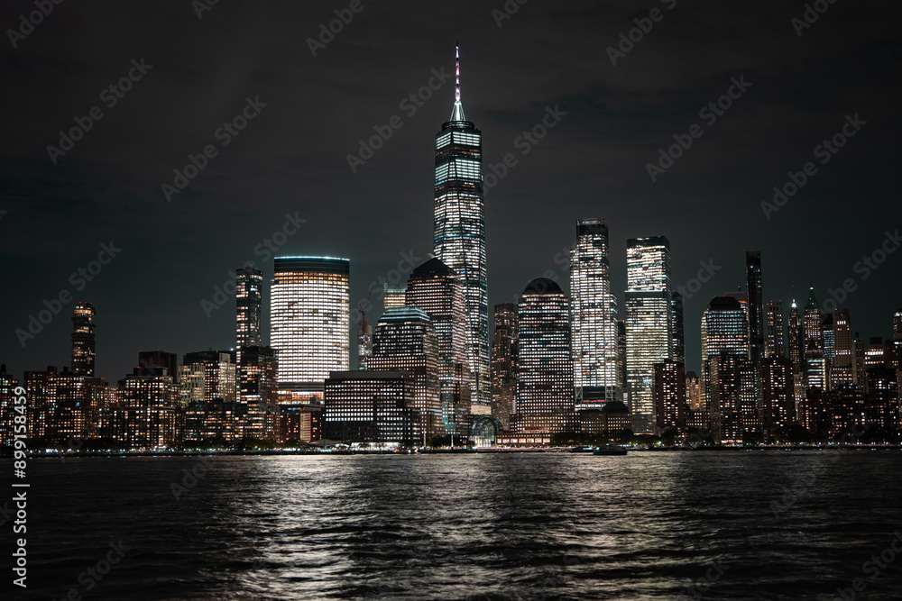 Obraz premium Night in The NYC city, USA, United States. Night day with iconic buildings. New York City NYC Manhattan Downtown Skyline, viewed from Jersey City, USA.