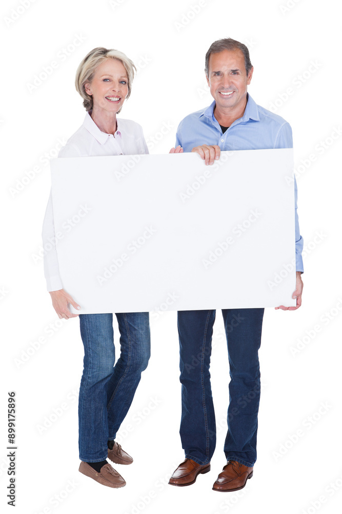 Elderly couple with smiles holds a blank placard Elderly couple with smiles holds a blank placard