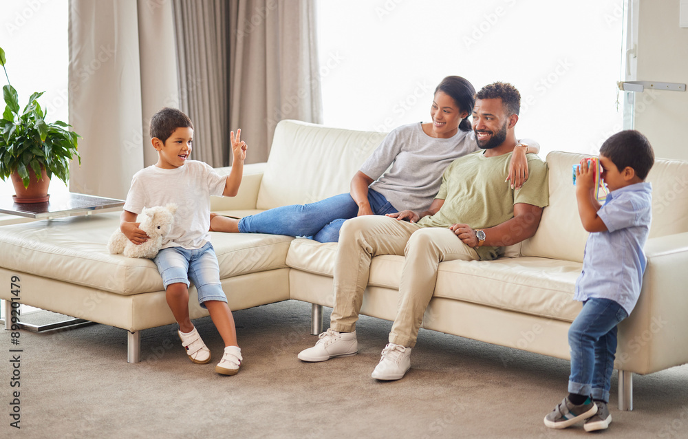 Happy family, parents and kids with toy camera for picture, peace sign and bonding together on sofa. Mother, father and brothers play in home living room for game, love and care with stuffed animal Happy family, parents and kids with toy camera for picture, peace sign and bonding together on sofa. Mother, father and brothers play in home living room for game, love and care with stuffed animal