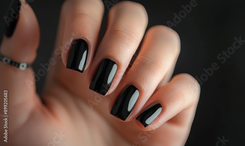 Closeup of woman hand with manicure with black colored gel nail polish photo