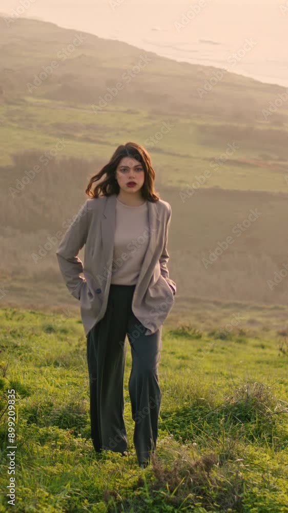 Attractive girl climbing hill covered green grass vertical. Woman walking ocean Attractive girl climbing hill covered green grass vertical. Woman walking ocean