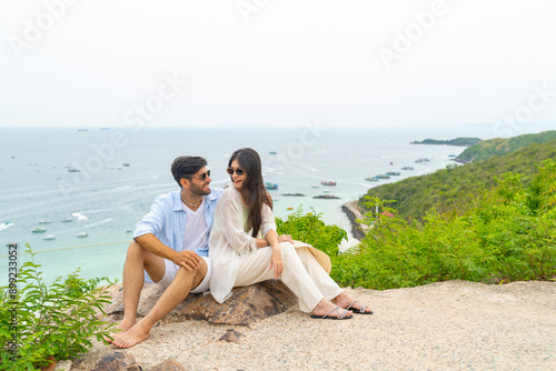 Happy Caucasian family couple enjoy outdoor lifestyle travel tropical island on summer beach holiday vacation. Husband and wife relaxing on mountain peak and looking beautiful nature of the sea. © CandyRetriever 
