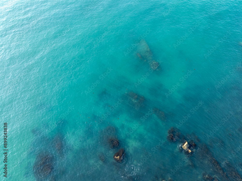 Fototapeta premium Aerial view of blue sea and rocky shore