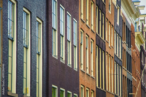 Photography A red brick building with symmetrical windows dominates the scene, creating a classic Amsterdam cityscape