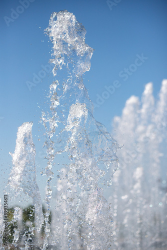 The fountain splashes in the blue sky. Water in flight.