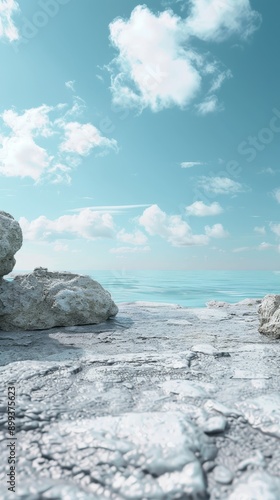  A bench atop a rocky shore, facing a body of water with a blue sky behind photo