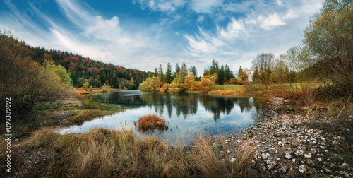 Idyllic landscape at a German lake surrounded by forests and beautiful vegetation, with gorgeous clouds in the blue sky photo