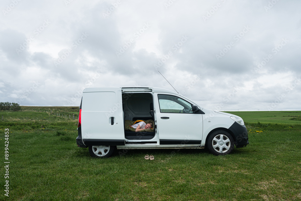 young woman sleeps in a sleeping bag in a camper van in Iceland young woman sleeps in a sleeping bag in a camper van in Iceland