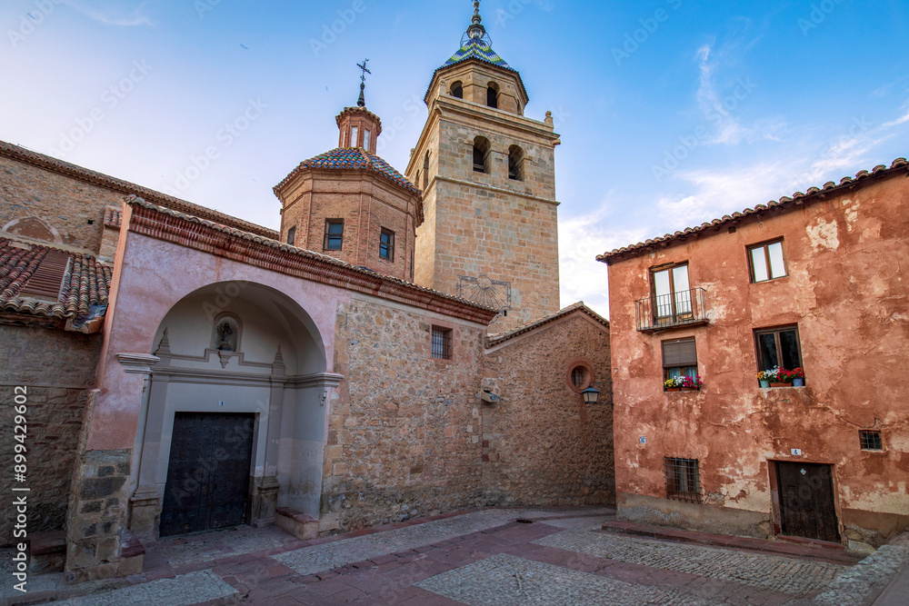 Fototapeta premium View of the side entrance of the Albarracín cathedral, Teruel, Aragon, Spain, from the Plaza de la Seo with sky with evening light