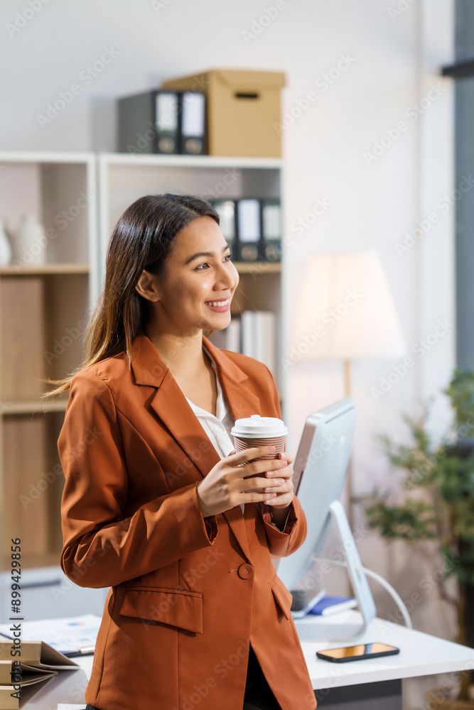 An Asian businesswoman sits at a table, working with a smile. She manages her online Kuya business with enthusiasm, showcasing her dedication and positive attitude while handling tasks efficiently. An Asian businesswoman sits at a table, working with a smile. She manages her online Kuya business with enthusiasm, showcasing her dedication and positive attitude while handling tasks efficiently.