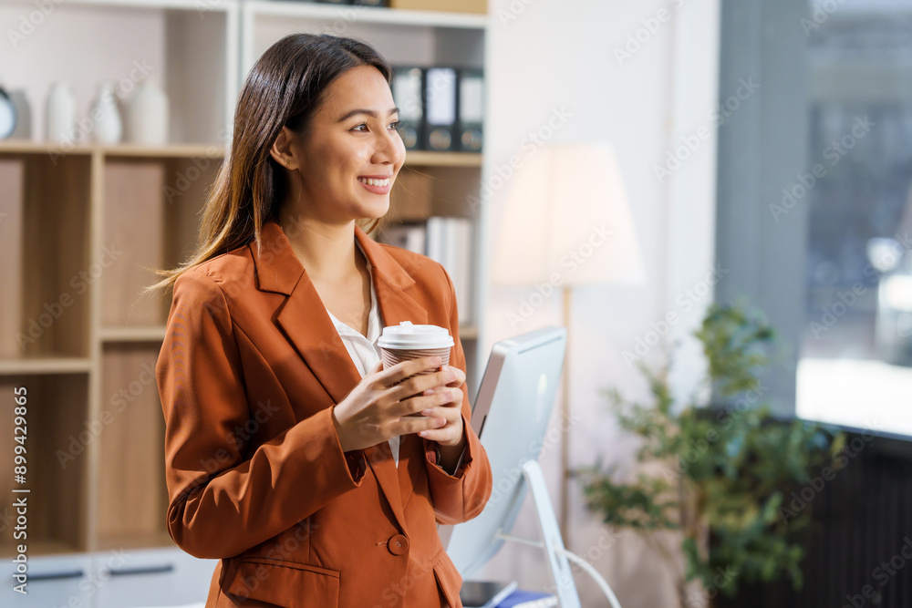 An Asian businesswoman sits at a table, working with a smile. She manages her online Kuya business with enthusiasm, showcasing her dedication and positive attitude while handling tasks efficiently. An Asian businesswoman sits at a table, working with a smile. She manages her online Kuya business with enthusiasm, showcasing her dedication and positive attitude while handling tasks efficiently.