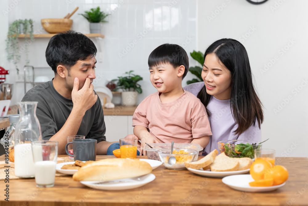 happy family together. Asian parent eating breakfast with little son in the kitchen. happy family together. Asian parent eating breakfast with little son in the kitchen.