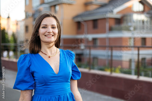 Free Download Close-up portrait of a young happy woman on a walk in a modern city, looking at the camera, copy space - GFXLoad