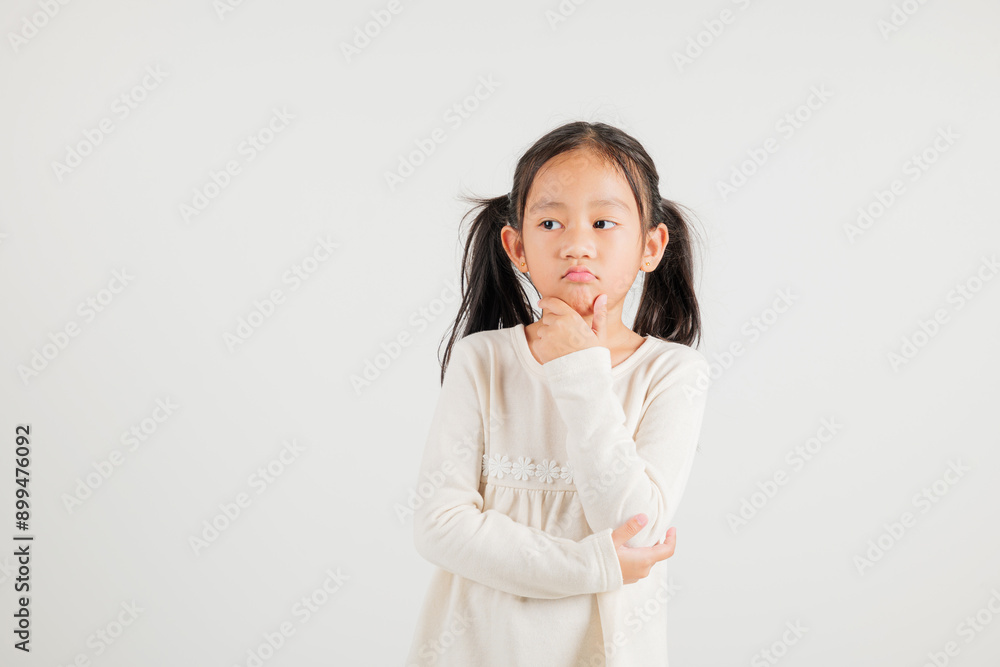 Portrait Asian kid girl deep in thought, standing with chin in hand, pondering a question. Studio shot isolated on white with ample copy space, kindergarten child portraying contemplative expression Portrait Asian kid girl deep in thought, standing with chin in hand, pondering a question. Studio shot isolated on white with ample copy space, kindergarten child portraying contemplative expression
