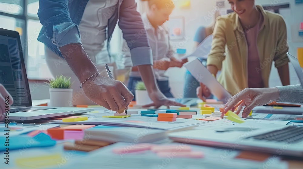 Fototapeta premium Close-up of a Hand Writing on Papers with Sticky Notes During a Business Meeting