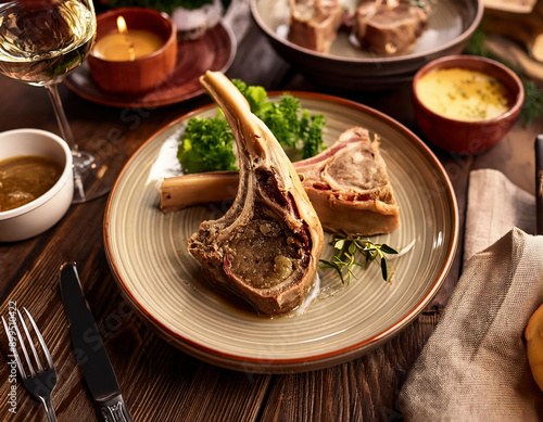 Beef Bone Marrow with garlic and garnitures on a rustic wooden table photo