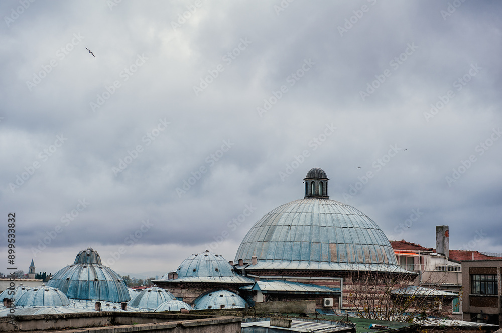 The domes of Istanbul's historical architecture stand against an overcast sky. The city's skyline showcases ancient Ottoman structures The domes of Istanbul's historical architecture stand against an overcast sky. The city's skyline showcases ancient Ottoman structures