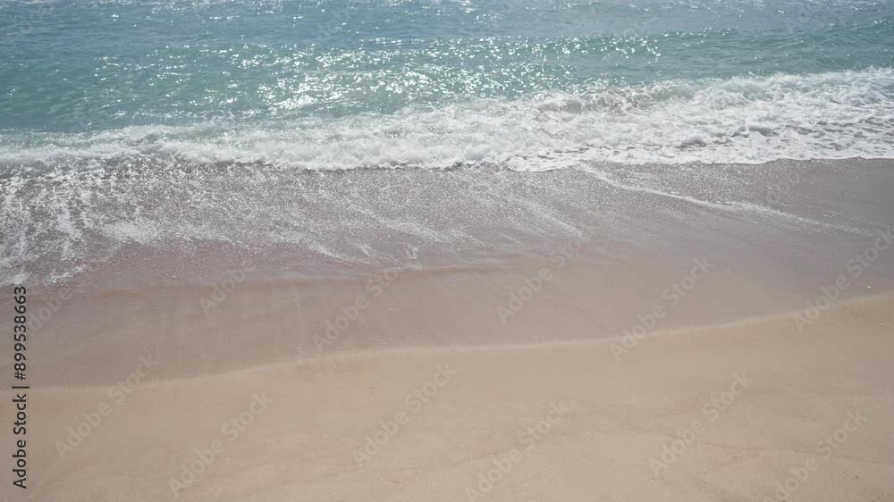 Tranquil beach with gentle waves lapping the sandy shore under a sunny sky Tranquil beach with gentle waves lapping the sandy shore under a sunny sky