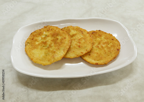 Close-up of three Bindaetteok(green-gram pancake) on white dish and marble floor, South Korea
 photo