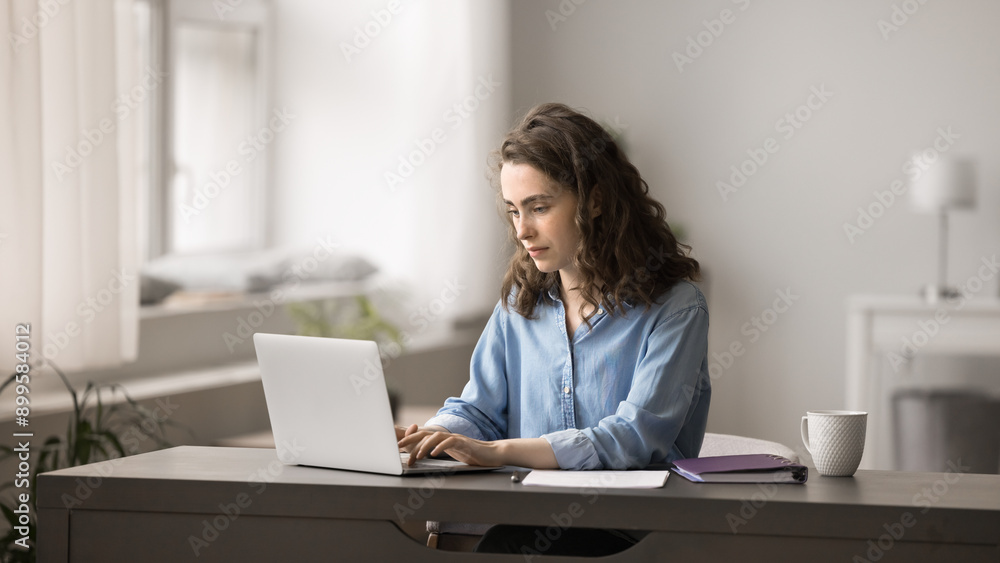Attractive young woman working on studying on-line on laptop, sit at desk at home office, lead correspondence to client, e-mailing, solve business, e-learning using modern wireless device and internet Attractive young woman working on studying on-line on laptop, sit at desk at home office, lead correspondence to client, e-mailing, solve business, e-learning using modern wireless device and internet