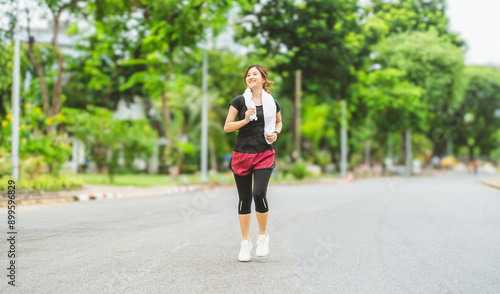 Asian woman jogging practicing for marathon exercise at outdoor public park