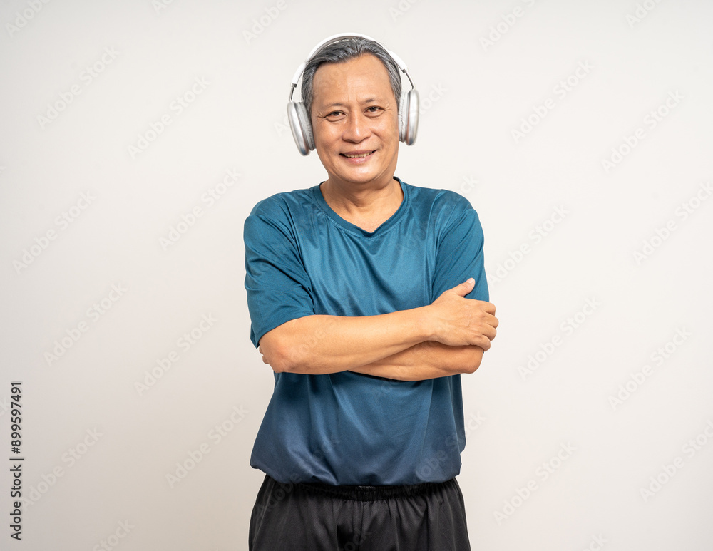Senior asian old man with sportswear with headset on isolated white background. Portrait happy healthy fit and firm attractive sporty mature man standing pose exercise workout in studio. Senior asian old man with sportswear with headset on isolated white background. Portrait happy healthy fit and firm attractive sporty mature man standing pose exercise workout in studio.