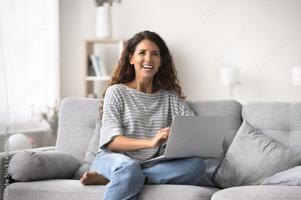 Happy Latina woman enjoy wireless internet, sit on cozy sofa with laptop, communicates through e-dating website, browse social network, shopping, websurfing, spend time on internet on pastime at home Happy Latina woman enjoy wireless internet, sit on cozy sofa with laptop, communicates through e-dating website, browse social network, shopping, websurfing, spend time on internet on pastime at home