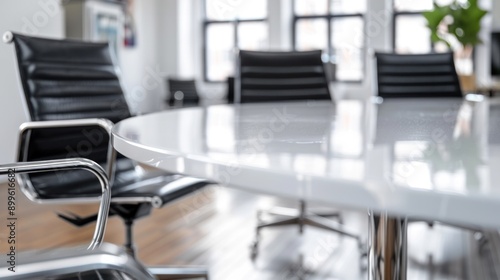 A close-up image of a white meeting table with black armchairs in a modern contemporary meeting room photo