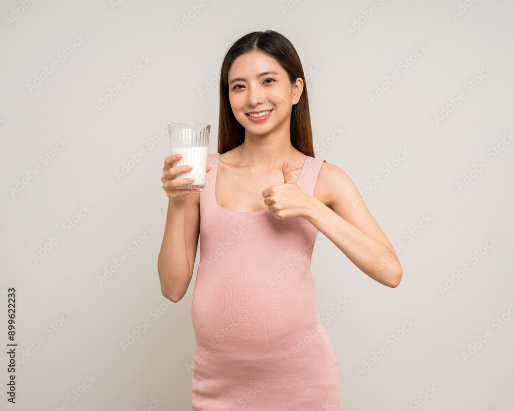 Happy Pregnant asian woman stroking touch belly motherhood drinking milk on isolated background. Family planning maternity and pregnancy with insurance for child health. Happy Pregnant asian woman stroking touch belly motherhood drinking milk on isolated background. Family planning maternity and pregnancy with insurance for child health.