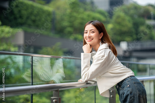 Young asian woman fashion lifestyle with headphone standing posing in urban city downtown. Happy attractive charming asian female living in city. People and lifestyle.