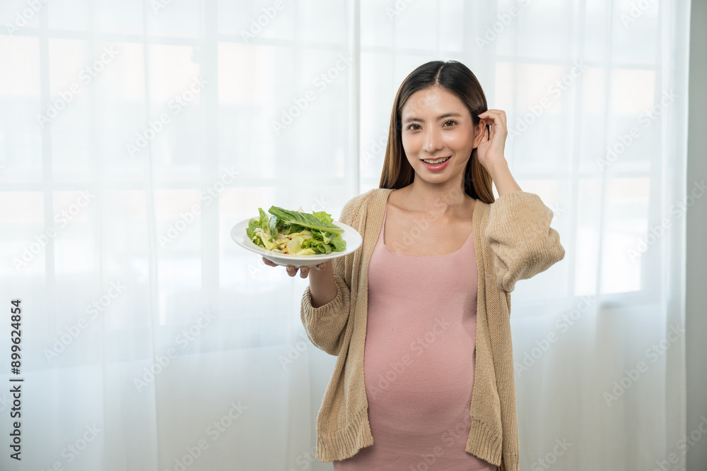 Happy pregnant woman eating vegetable salad and smiling to camera, concept of healthy mother taking health care and nourish her fetal and waiting her childbirth. Happy pregnant woman eating vegetable salad and smiling to camera, concept of healthy mother taking health care and nourish her fetal and waiting her childbirth.