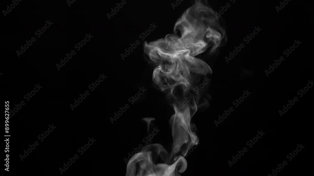 Vapor from the Surface of Hot Coffee. White steam rises light, graceful twists on a black background. The jet lifted out of the cup of hot water Vapor from the Surface of Hot Coffee. White steam rises light, graceful twists on a black background. The jet lifted out of the cup of hot water