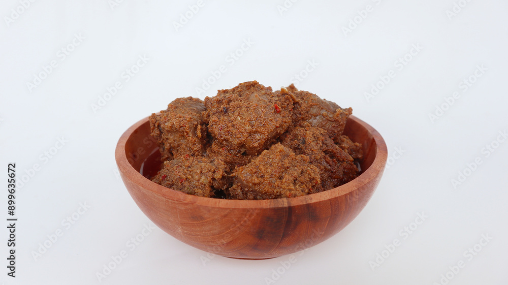 Rendang Padang. Spicy beef stew from Padang, Indonesia. The dish is arranged among the spices and herbs used in the recipe. isolated on white background Rendang Padang. Spicy beef stew from Padang, Indonesia. The dish is arranged among the spices and herbs used in the recipe. isolated on white background