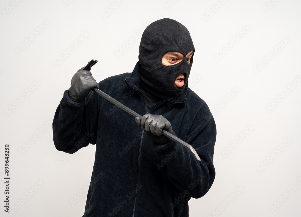 Thief in uniform black jacket various pose on isolated background. The Robber terrorism criminal escapes with balaclava and crowbar entering a house for stealing Housebreak Thief in uniform black jacket various pose on isolated background. The Robber terrorism criminal escapes with balaclava and crowbar entering a house for stealing Housebreak